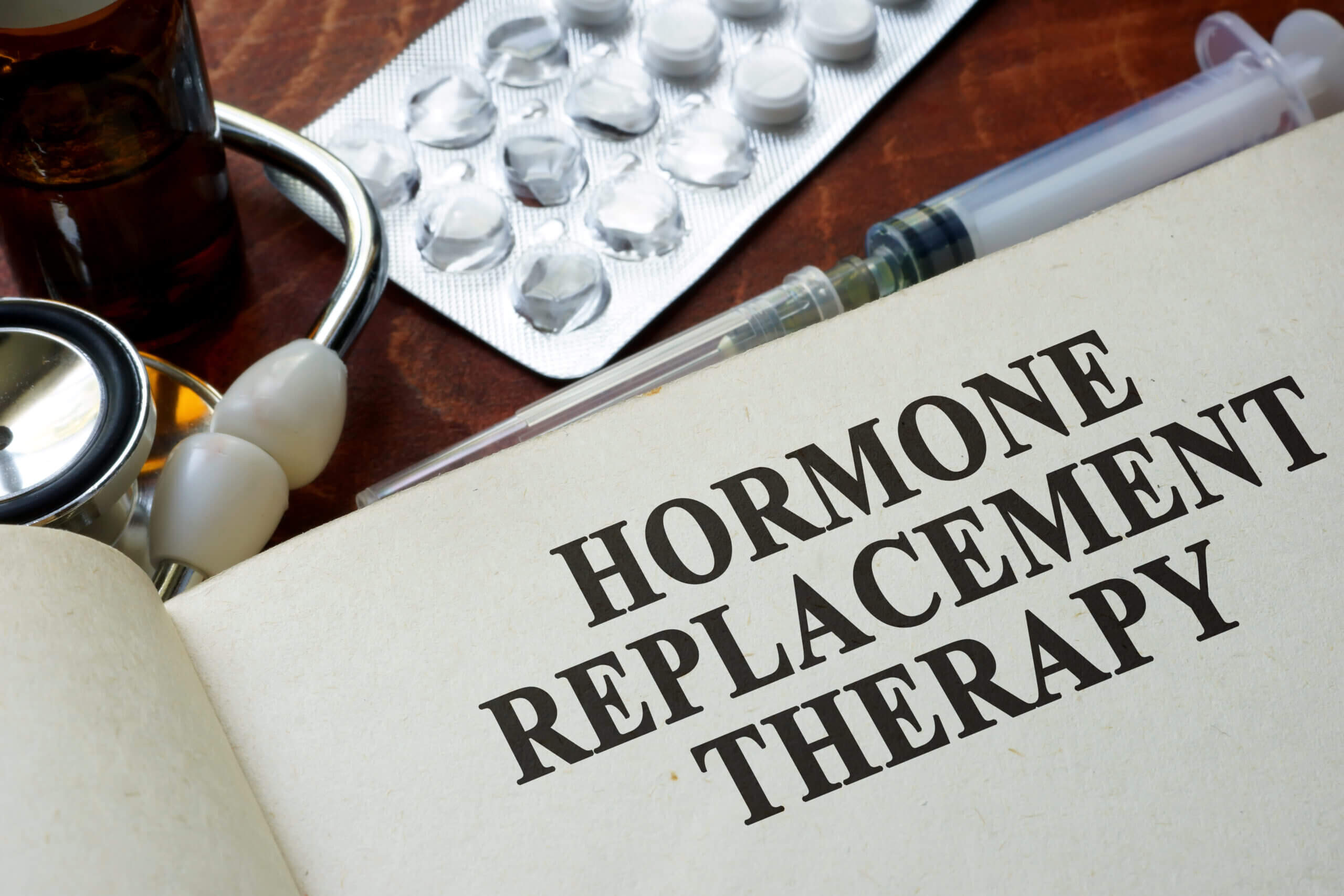 Hormone Replacement Therapy Text with Injection and Medicine Background | Aluma Wellness in Altamonte Springs, FL